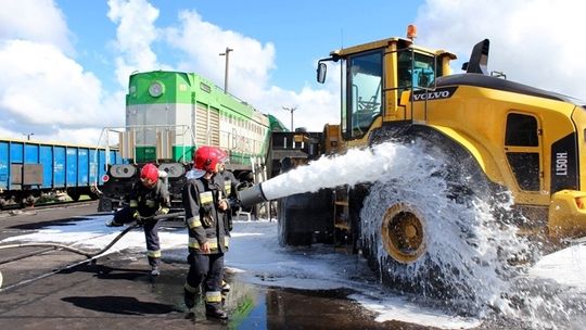 Zderzenie lokomotywy i ładowarki. Ćwiczenia w bazie przeładunkowej